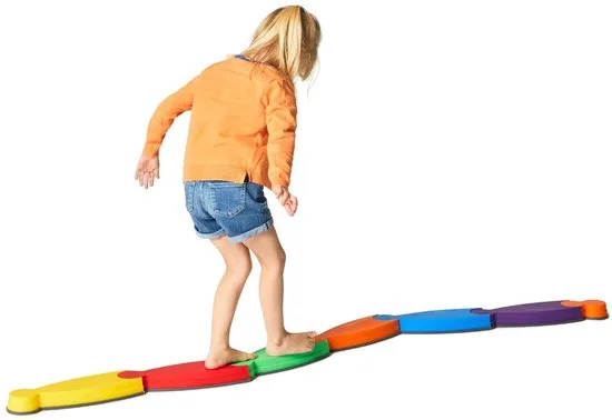 Kind dat over het gekleurde lage Gonge River balanceerpad loopt.